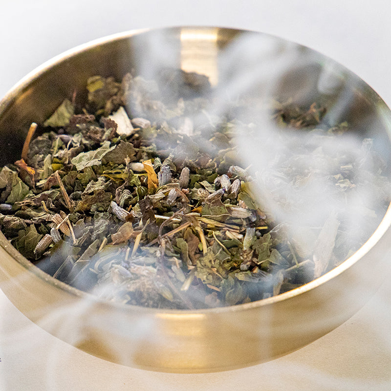 Magical Mind Smoke blend in gold bowl with Lemon Balm, Skullcap, Lavender and Mugwort surrounded by smoke.