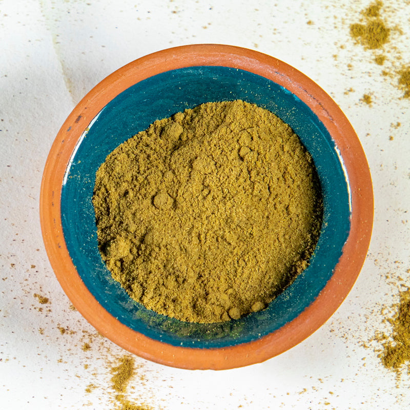 Goldenrod powder herb in blue clay bowl with white background and herb surrounding.